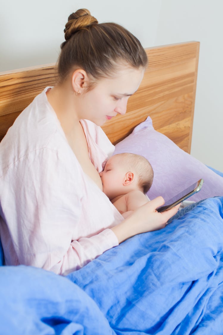 Mother Breastfeeding Her Little Baby While Checking Mobile Phone