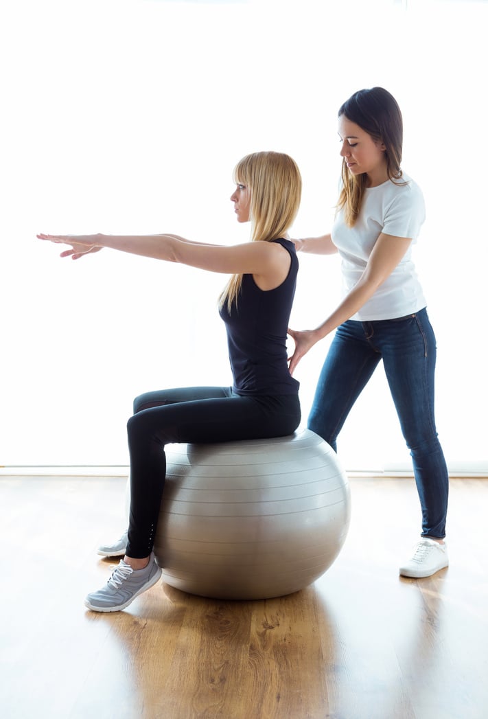 Physiotherapist Helping Patient to Do Exercise on Fitness Ball I